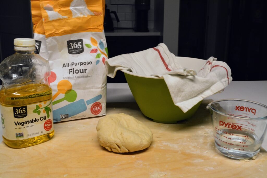 Ingredients for pierogi dough include flour, vegetable oil, and warm water